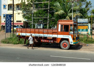 THENI, TAMIL NADU, INDIA - OCTOBER 28, 2018: A Tata Truck, With Its Rear Wheel Missing, Stands Jacked Up, By The Roadside Near To A Small Tyre Repair Facility Where The Wheel Is Being Fixed.    