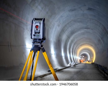 Theodolite at underground railway tunnel construction work. Construction survey equipment instrument on concrete circular tunnel background.