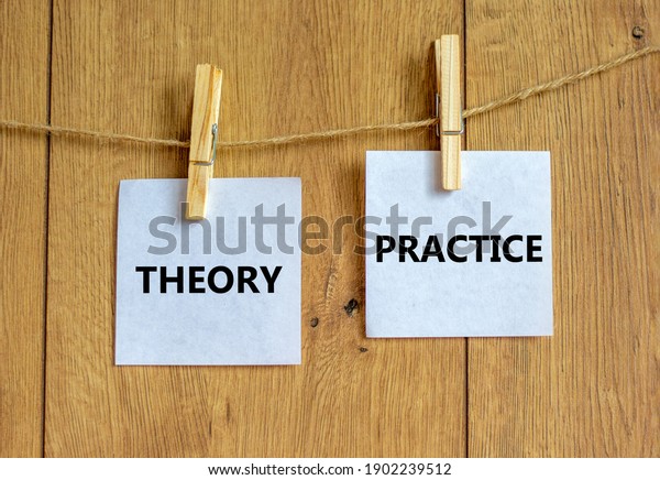 Theory and\
practice symbol. Wooden clothespins with white sheets of paper.\
Words \'theory practice\'. Beautiful wooden background. Business,\
theory and practice concept, copy\
space.