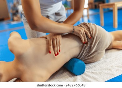 Therapeutic exercise kinesitherapy of little boy. The boy lies on one side, exercises for correcting the spine, pelvis, scoliosis. - Powered by Shutterstock