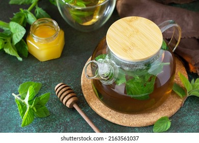 Therapeutic herbal green tea. Hot tea with honey mints in a glass teapot on a stone table.  - Shutterstock ID 2163561037