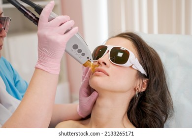 Therapist cosmetologist makes laser treatment for woman's face in SPA beauty clinic. Facial laser epilation hair removal procedures. Facial rejuvenation medical correction. Close up, selective focus - Shutterstock ID 2133265171