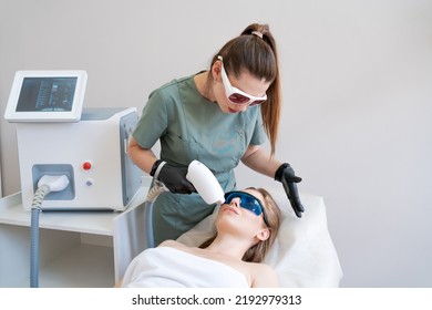 Therapist Cosmetologist Undergoes Laser Treatment On Face Young Woman In Beauty Clinic. Facial Laser Hair. Epilation Procedures. Satisfied Customer, Selective Focus.