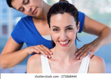 Therapist doing back massage to her patient in medical office