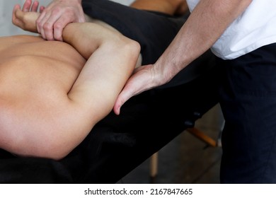 Therapist doing back sports massage to male patient athlete at studio