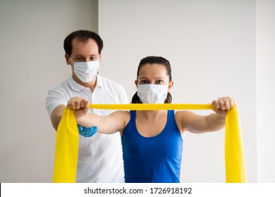 Therapist Doing Band Resistance Shoulder Physical In Face Mask