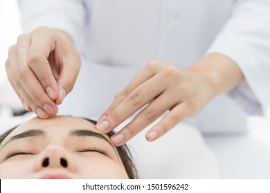 Therapist Giving acupuncture Treatment with Asian female An Acupuncture Therapy at Spa Center. patient having traditional Chinese treatment. Relaxed Woman Receiving Acupuncture Treatment In Beauty Spa - Powered by Shutterstock