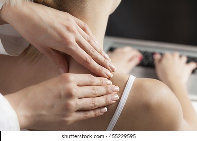 Therapist giving a massage on a woman's neck in office