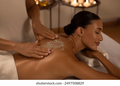 Therapist hands applying sea salt on woman back, healthcare and spa concept. Lady getting healing salt massage at modern spa, in serene atmosphere - Powered by Shutterstock