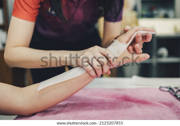 Therapist making asissistive device for\
immobilize patient hand. Splint service for hand injury\
rehabilitation of occupational therapy\
clinic.