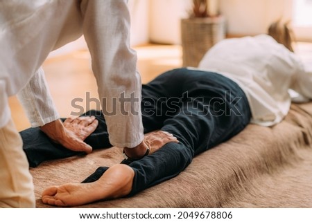 Therapist massaging woman’s legs. Woman getting shiatsu leg massage.