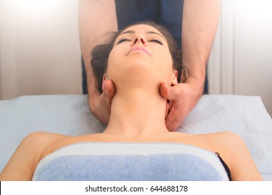 Therapist massaging the neck of woman In the by a professional in studio