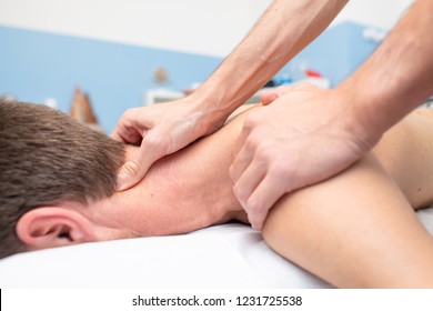 Therapist massaging the neck of young man.