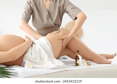 Therapist massaging pregnant woman's leg in spa salon, closeup - Powered by Shutterstock