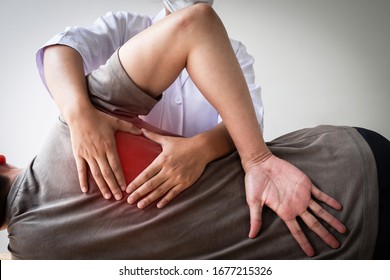 Therapist treating injured back of male patient, Physical therapy concept. - Shutterstock ID 1677215326