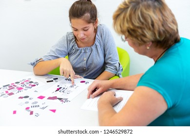 Therapist Working With A Teenage Girl With Learning Difficulties To Master Logical Tests.