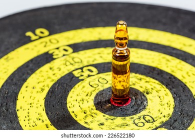 Therapy concept: drug ampule on old yellow target board. Shallow depth of field