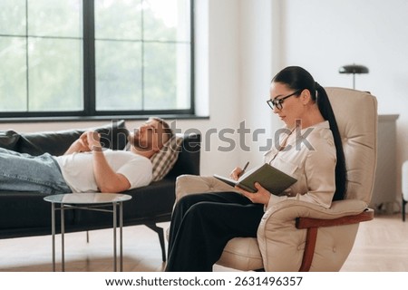 Therapy session. Man is lying down at couch and talking, at psychologist appointment.