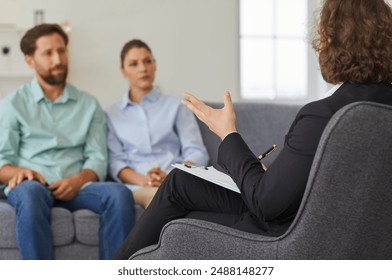 Therapy session, a serious family couple seeks support and consulting from a psychologist to address and resolve underlying problems. Positive impact of psychotherapy in resolving family issues. - Powered by Shutterstock