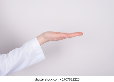 Therapy Treatment Remedy Cure Concept. Half Cropped  Close Up Photo Of Hand With White Coat Sleeve Holding Invisible Object Isolated Over Grey Color Background Copyspace