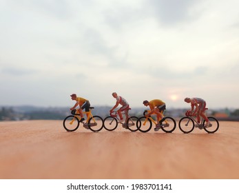 There is bicycle miniature toys on the brown table with blurred sky as a background. - Shutterstock ID 1983701141