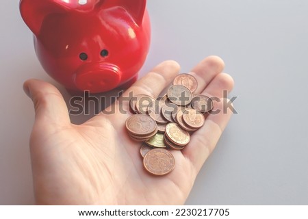 There are a bunch of small euro cents on the man's palm, which he took out of the piggy bank. The concept of poverty, unemployment. Selective focus.