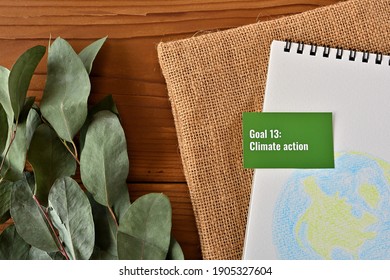 There Is Card With The Statement Goal 13:
Climate Action
 On It One Of The Goals Of The SDGs And A Illustration Of The Earth.