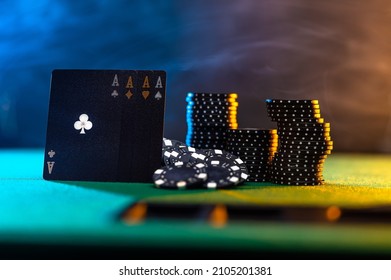 There Are Cards And Stacks Of Chips On The Green Poker Table. Multicolored Smoky Background. No People. Casino. Online Casino. Gambling Business. Night Club. Risk, Chance Of Luck.