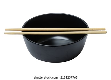 There Is A Clean Black Ceramic Bowl With Wooden Chopsticks On The White Background. The Food Photography Of Empty Plate With Sticks. This Is The Isolated Image.