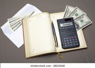 There are diary, envelope with dollars and a calculator on the grey background.