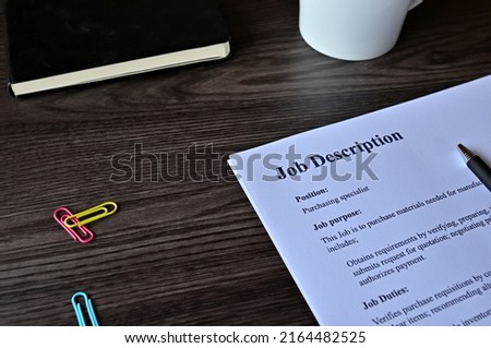 There is dummy documents that created for the photo shoot on the desk about Job Description.