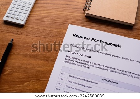 There is dummy documents that created for the photo shoot on the desk about Request For Proposal.