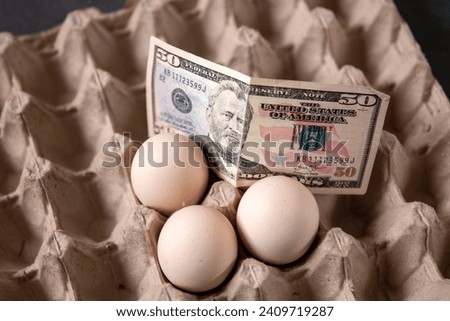 There are eggs in the egg carton and 100 dollars on it, implying an increase in egg prices,