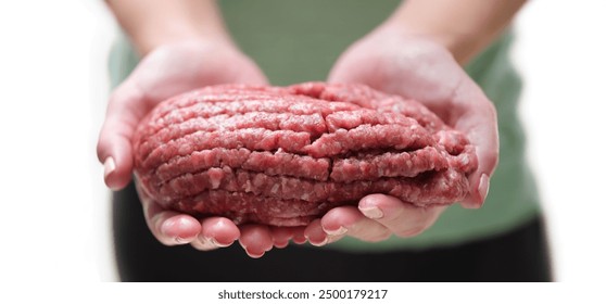 There is a lot of fresh red fatty minced meat in the palms, close-up. Blank for burgers. Using a meat grinder - Powered by Shutterstock