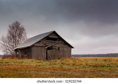 There is frost on the fields and barns of the Northern Finland after a cold autumn night. The winter is coming and the heavy clouds may predict snowfall.