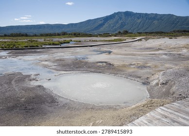 There is a hot puddle in the foreground. There is a wall of the Uzon caldera.