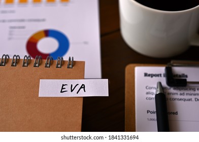 There Is A Laptop, A Cup Of Coffee, And A Sticky Note With The Word EVA Written On It. It Was An Abbreviation For Economic Value Added.