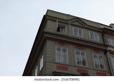 There is a large building that features an abundance of windows, as well as a beautiful balcony overlooking the surroundings