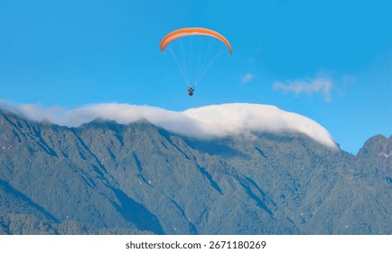 There is a large mountain range in the background with clouds covering the sky - Paraglider fly from Mount Babadag in Fethiye, Turkey
