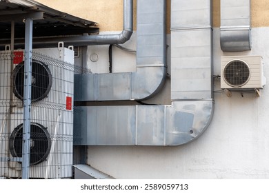 There is a large structure or building that has an extensive number of pipes protruding from various points on its exterior surface