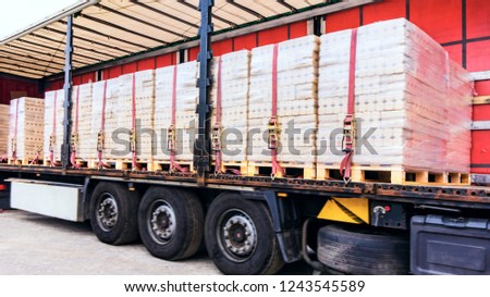  There is a loading to the truck trailer .  fastening of freight in the trailer .   transportation of freight Europe . industrial infrastructure . to fix freight .  Cargo container . 