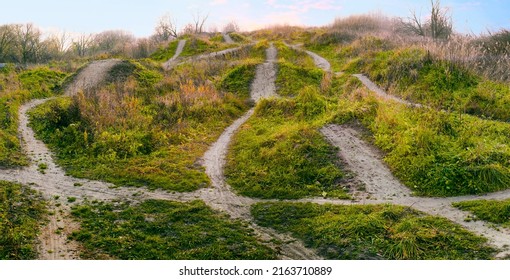 There Are Many Different Paths And Directions Through Dangerous Uneven Terrain. Winding Paths And Routes On Green Hills