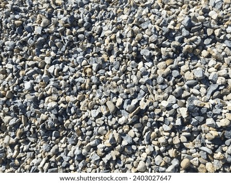 There are many small gravel stones on the side of the road