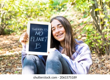 There Is No Planet B. Young Teenager Girl With Blackboard In A Forest. A More Sustainable Enviroment For A Better Planet.