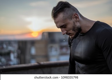There is no success without sweat. Young handsome man training hard and sweating. Man doing sports outside on the bridge. Outdoors recreation, stretching and training fit body