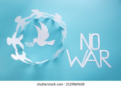 There is no war. People cut out of paper on a blue background protect the dove of peace.The concept of the World Peace Day