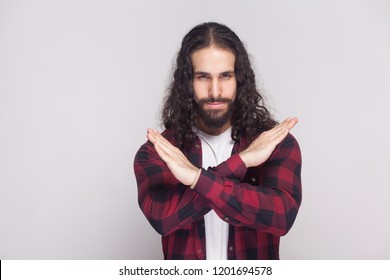 There Is No Way. Handsome Serious Man With Beard And Black Long Curly Hair In Casual Style, Checkered Red Shirt Standing Crossing Hands And Warning. Indoor Studio Shot, Isolated On Grey Background.