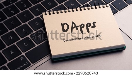 There is note book with the word Decentralized Applications on a laptop. It is an eye-catching image.