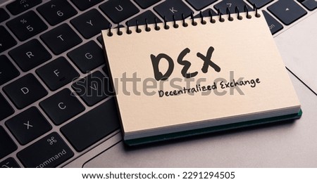 There is note book with the word DEX (Decentralized Exchange) on a laptop. It is an eye-catching image.