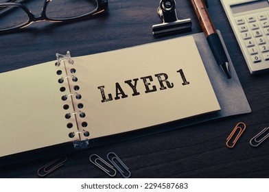 There is note book with the word Layer 1 on desk. It is an eye-catching image.